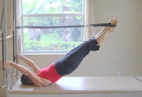 Leg springs pilates exercise on the cadillac apparatus